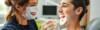 Dentiste souriant examine les dents d'un patient.